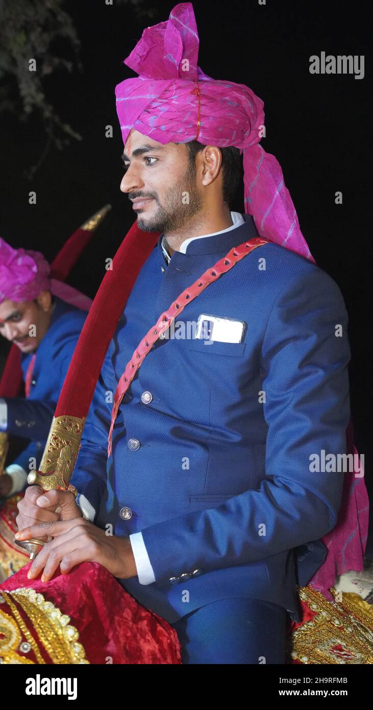 21 novembre 2021 Reengus, Rajasthan, Inde.Mariage hindou, deux groom indien ridant cheval blanc avec tissu bleu et turban rose avec les invités re Banque D'Images