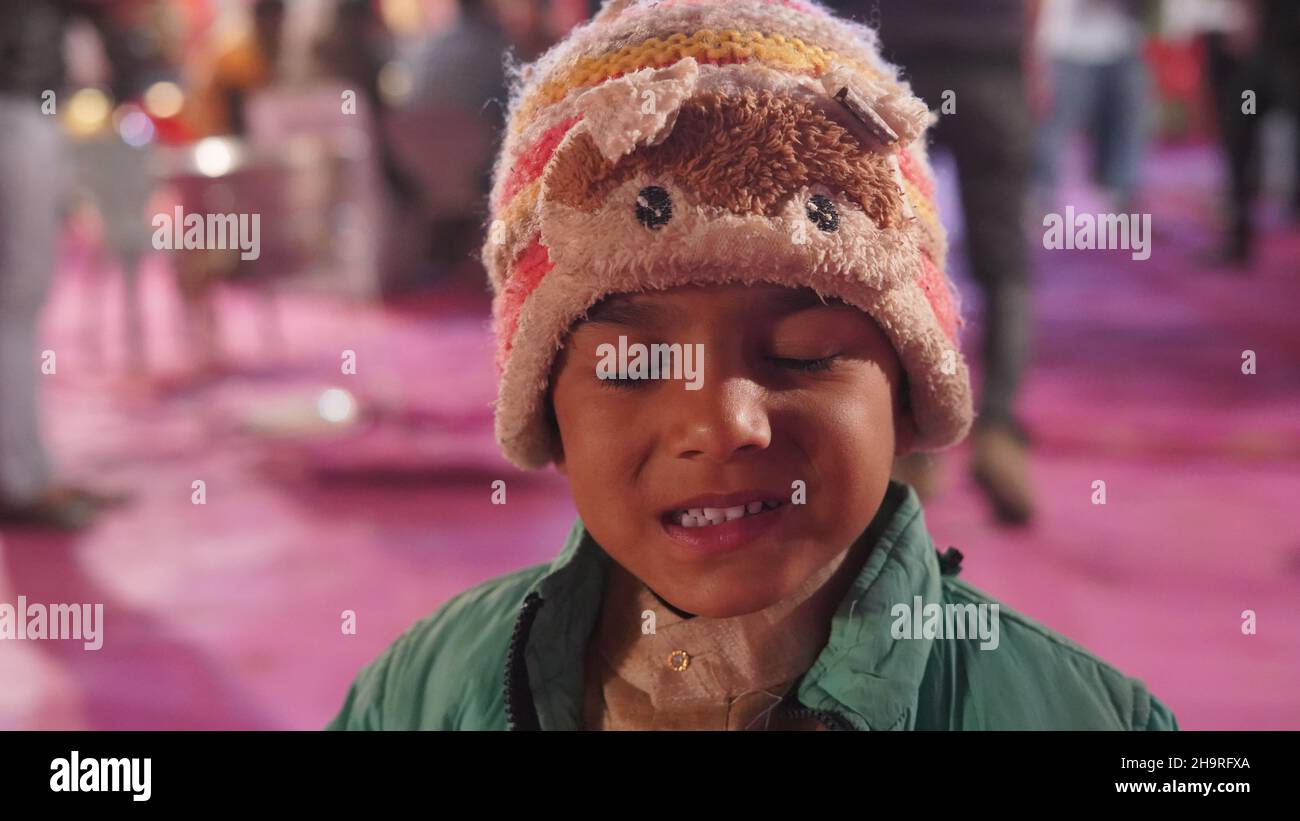 Adorable petit enfant indien en vêtements de laine et œil fermé devant l'appareil photo.Saison d'hiver et concept de mariage. Banque D'Images