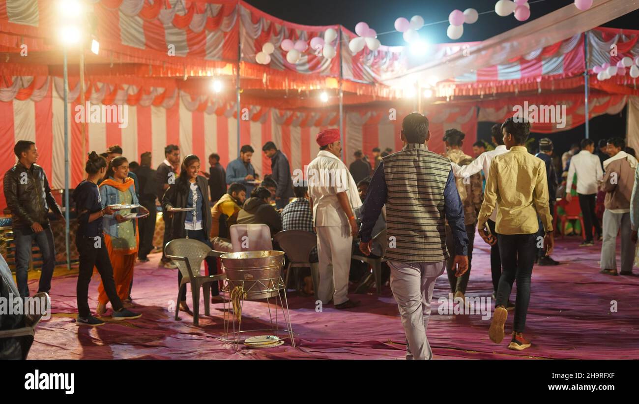 21 novembre 2021 Reengus, Rajasthan, Inde.Les membres de la famille indienne et les rafales mangeant de la nourriture à une fonction de mariage. Banque D'Images