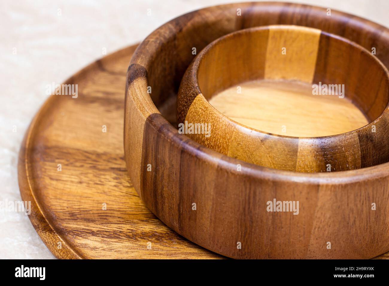 Bols écologiques traditionnels ronds en bois brun avec cuillère sur fond de table clair dans la cuisine. Banque D'Images