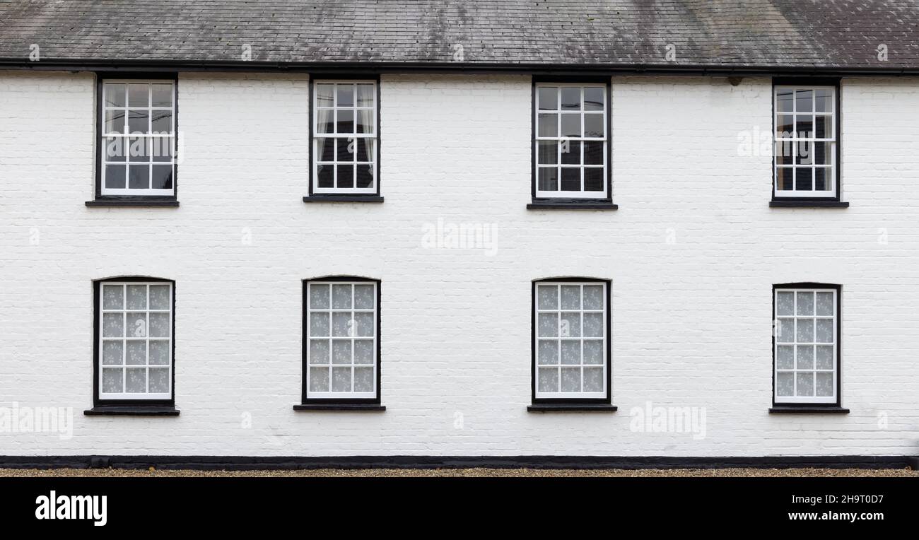 Côté d'une ancienne maison avec mur de briques blanches et fenêtres en bois blanc victorien.ROYAUME-UNI Banque D'Images