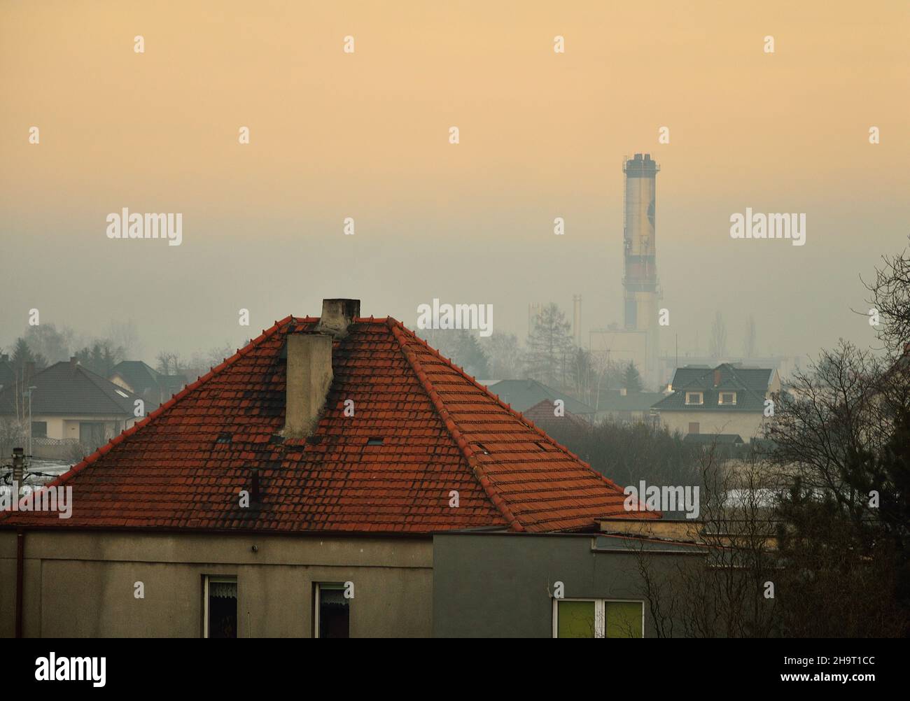 Toits, cheminées et fumée au-dessus de la ville le matin, jour d'automne.Crépuscule. Banque D'Images