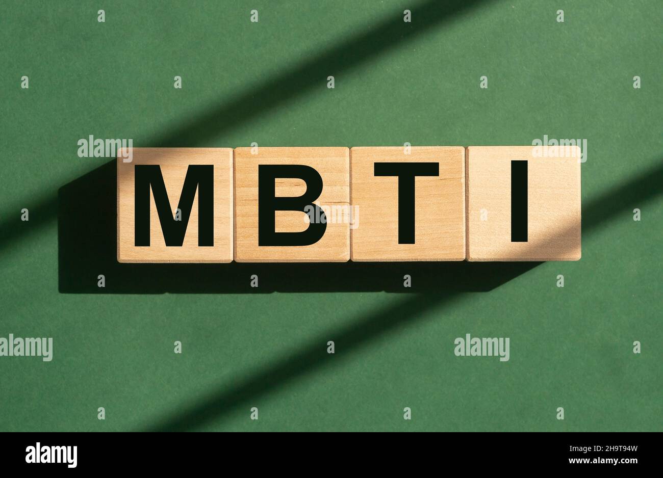 Mot MBTI sur cubes de bois sur fond vert. Banque D'Images