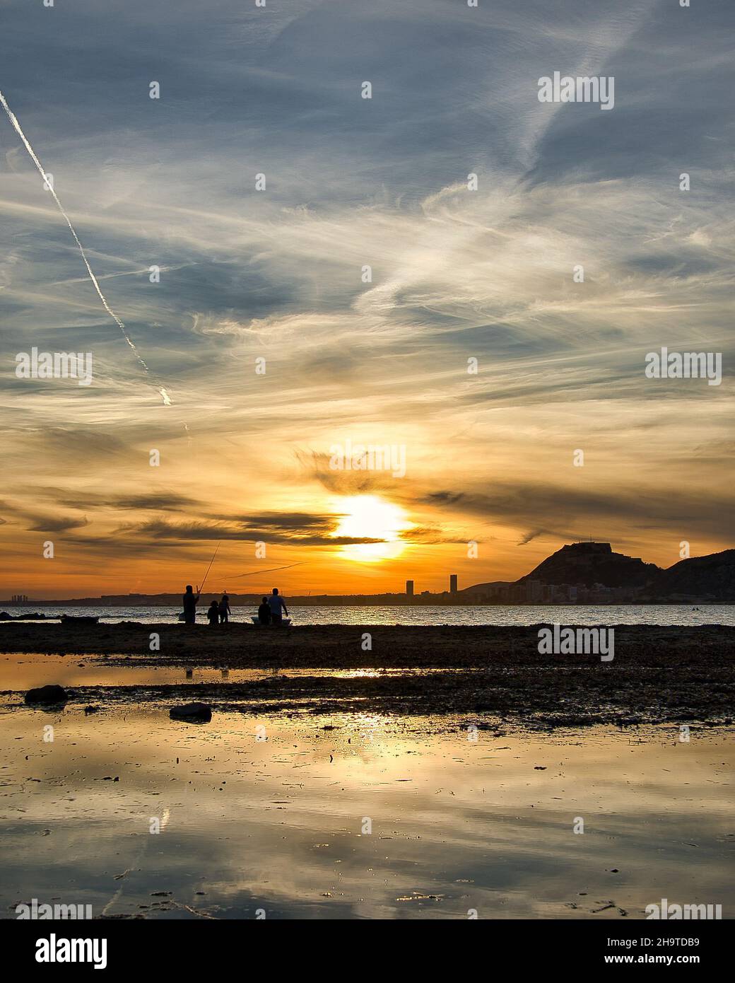 Coucher de soleil avec des reflets et de beaux nuages avec de nombreuses couleurs, sur la plage d'Albufereta à Alicante, Communauté Valencienne, Espagne, paysage Banque D'Images