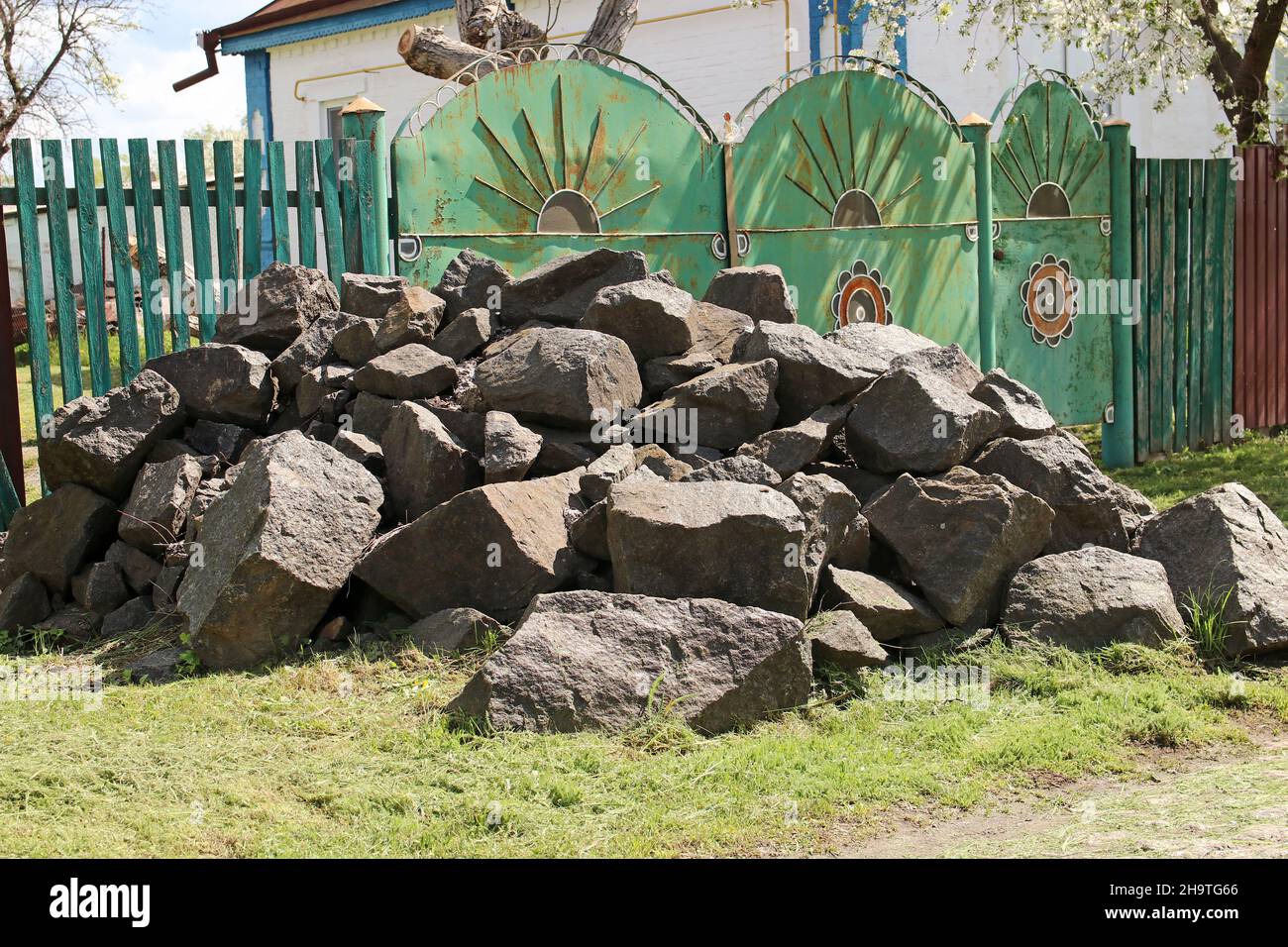 Une pile de pierres énormes près de la maison du village.Pierres de granit. Banque D'Images