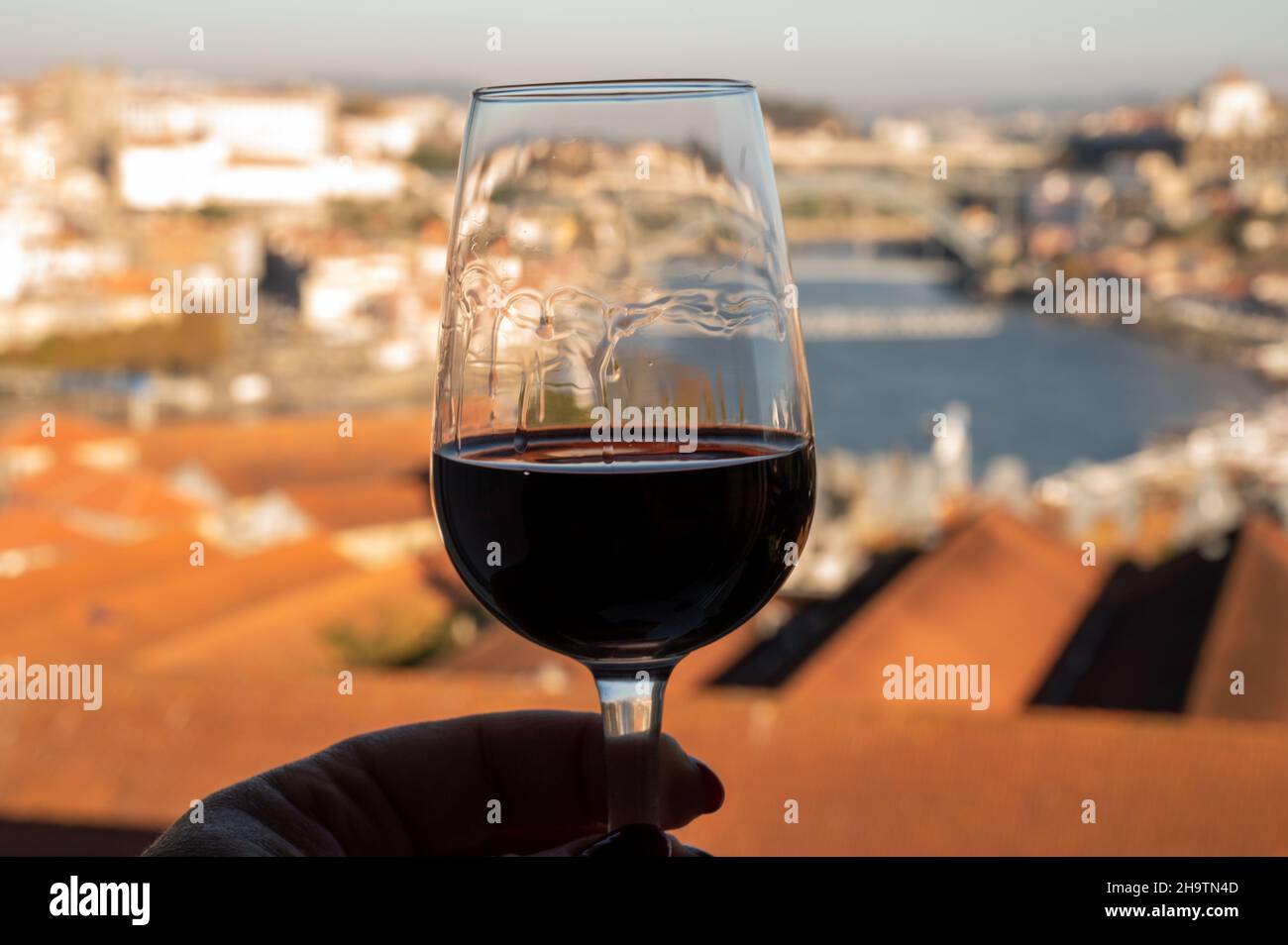 Dégustation de différents desserts fortifiés rubis, vins du port tawny en verres avec vue sur le Douro, les lodges de porto de Vila Nova de Gaia et la ville de Porto Banque D'Images