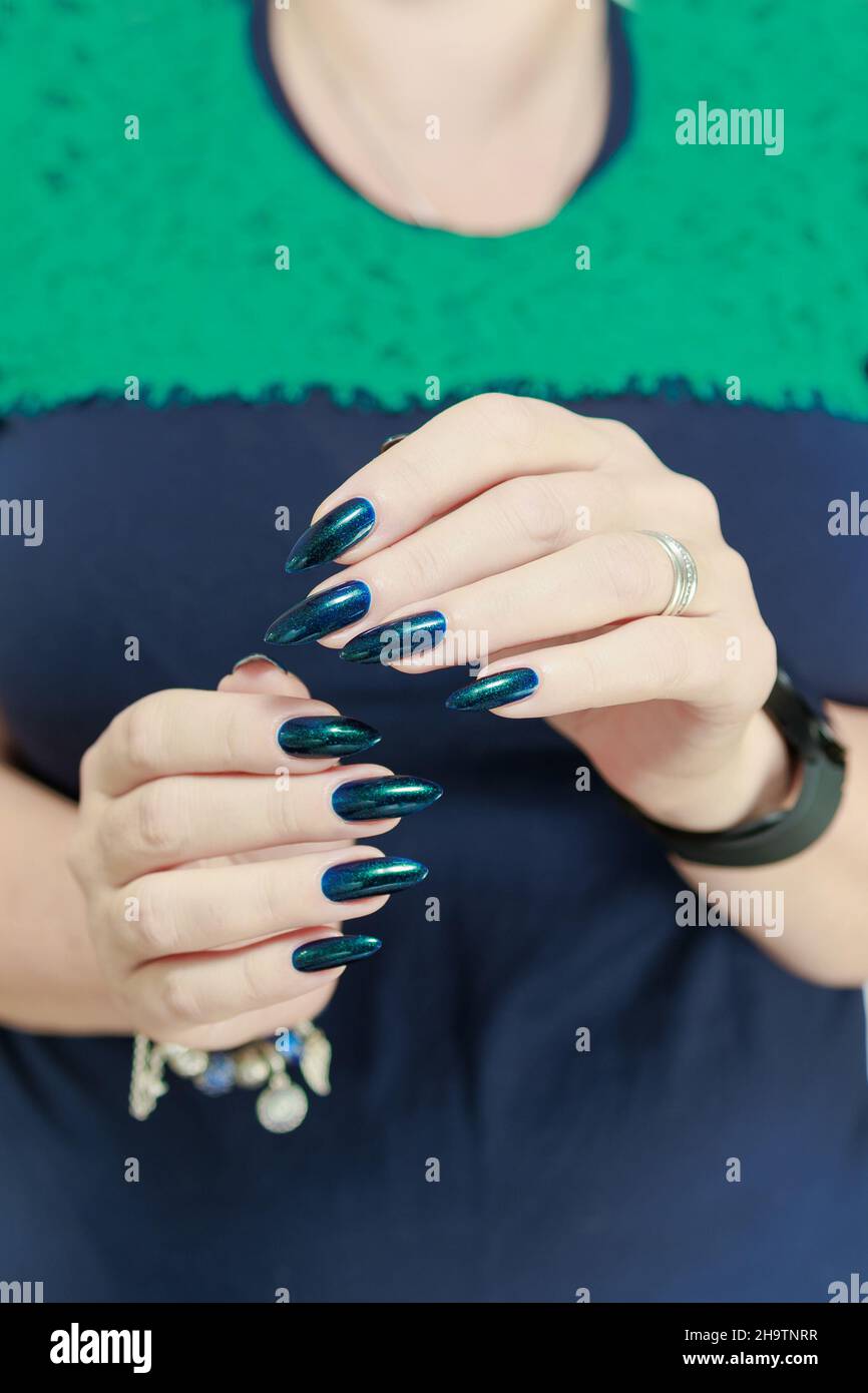 Belle main de femme avec de longs ongles et manucure turquoise vert et bleu  avec des bouteilles de vernis à ongles Photo Stock - Alamy