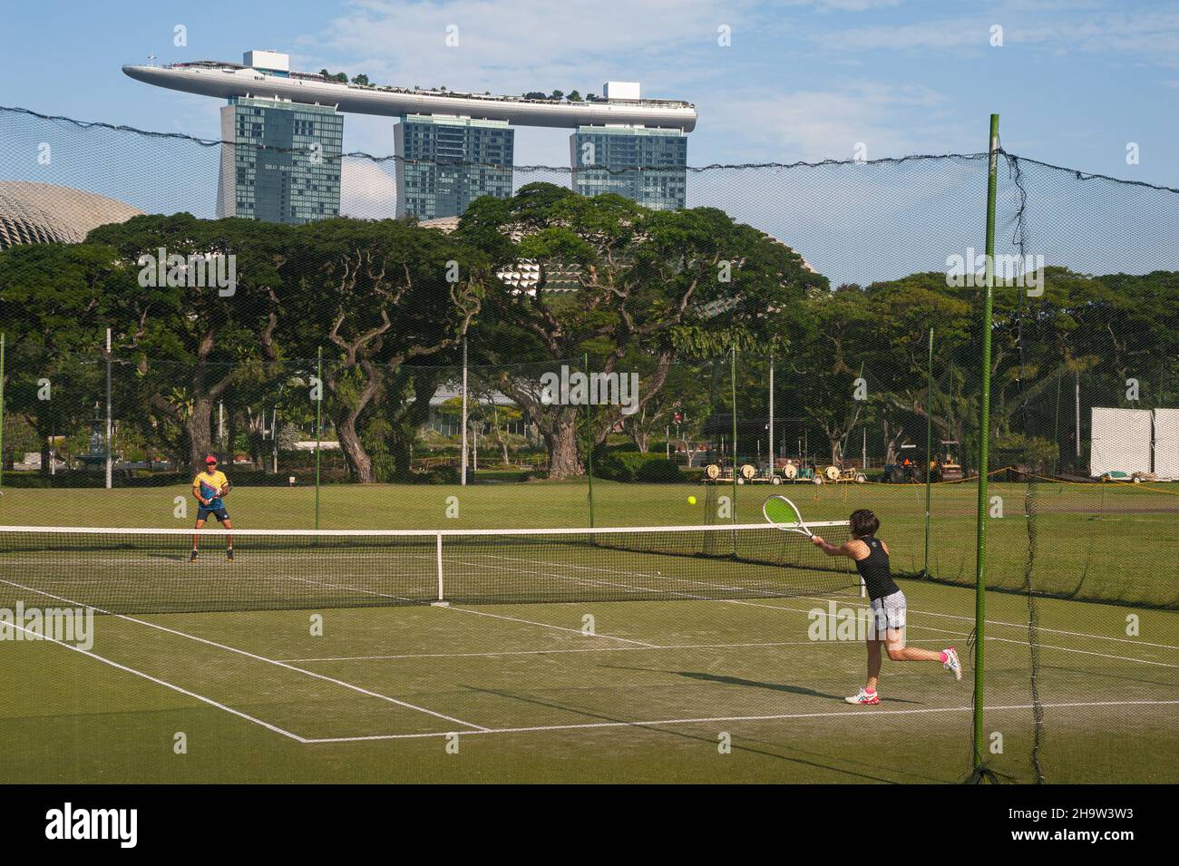 '24.07.2021, Singapour, , Singapour - deux joueurs jouant au tennis tandis que le Marina Bay Sands Hotel peut être vu en arrière-plan.0SL210724D009CAROEX. Banque D'Images '24.07.2021, Singapour, , Singapour - deux joueurs jouant au tennis tandis que le Marina Bay Sands Hotel peut être vu en arrière-plan.0SL210724D009CAROEX. Banque D'Images