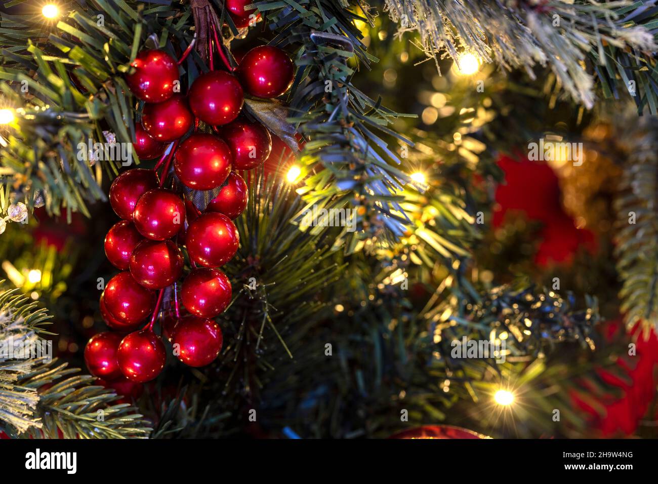Décoration d'arbres de Noël aux baies sur un arbre illuminé pour les fêtes de fin d'année Banque D'Images