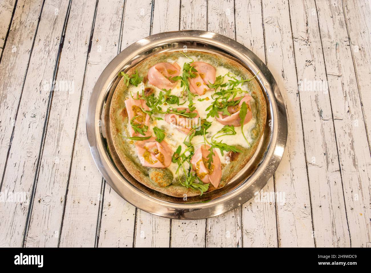 Pizza italienne avec pistache, mozzarella, arugula et mortadella de bologne sur un plateau métallique Banque D'Images