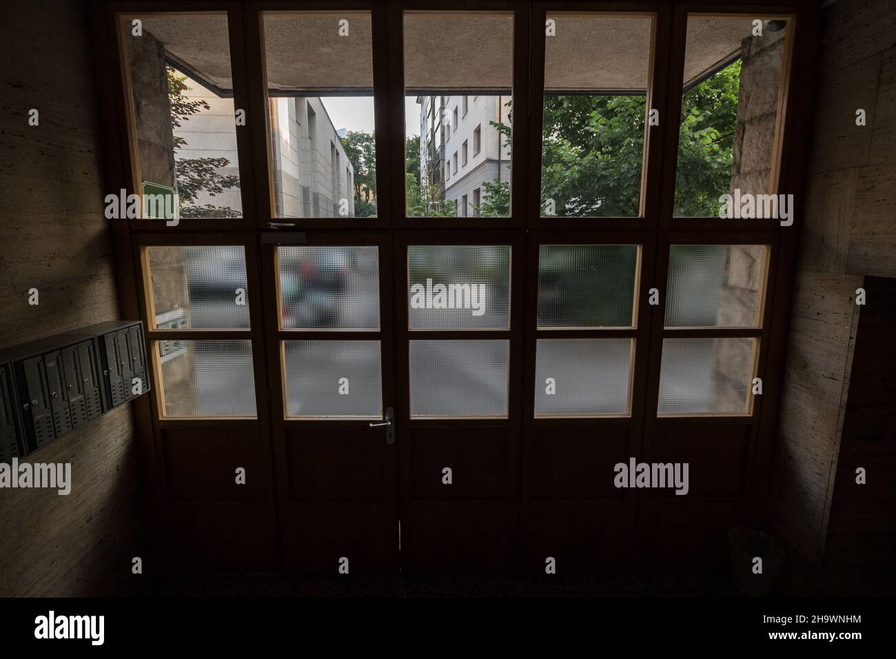 Photo de la porte d'entrée d'un immeuble à plusieurs immeubles à Ljubljana, en Slovénie, avec un accent sur la porte, la porte et quelques boîtes aux lettres. Banque D'Images