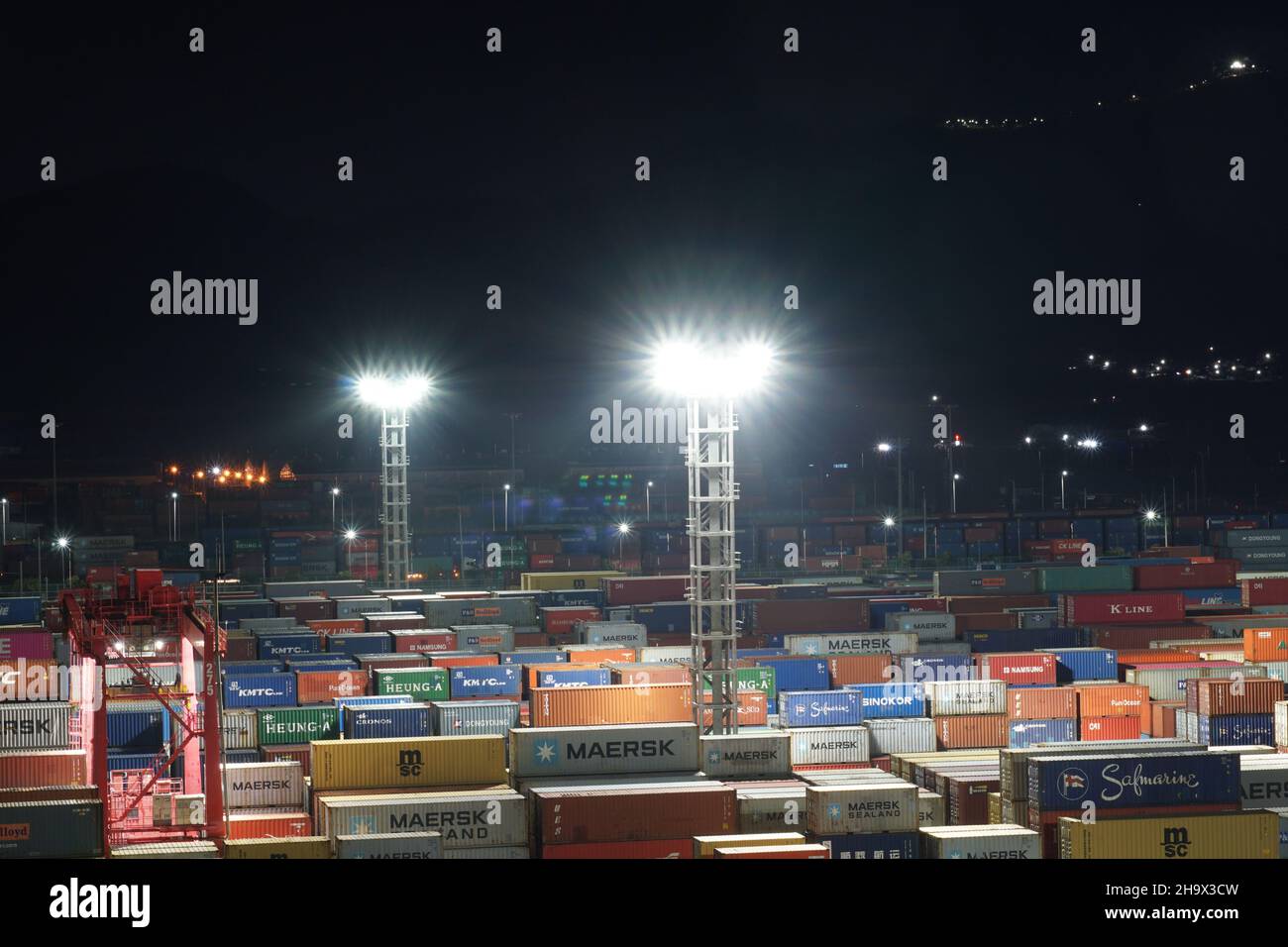 Beaucoup de conteneurs rangés de différents expéditeurs observés pendant la nuit. Banque D'Images