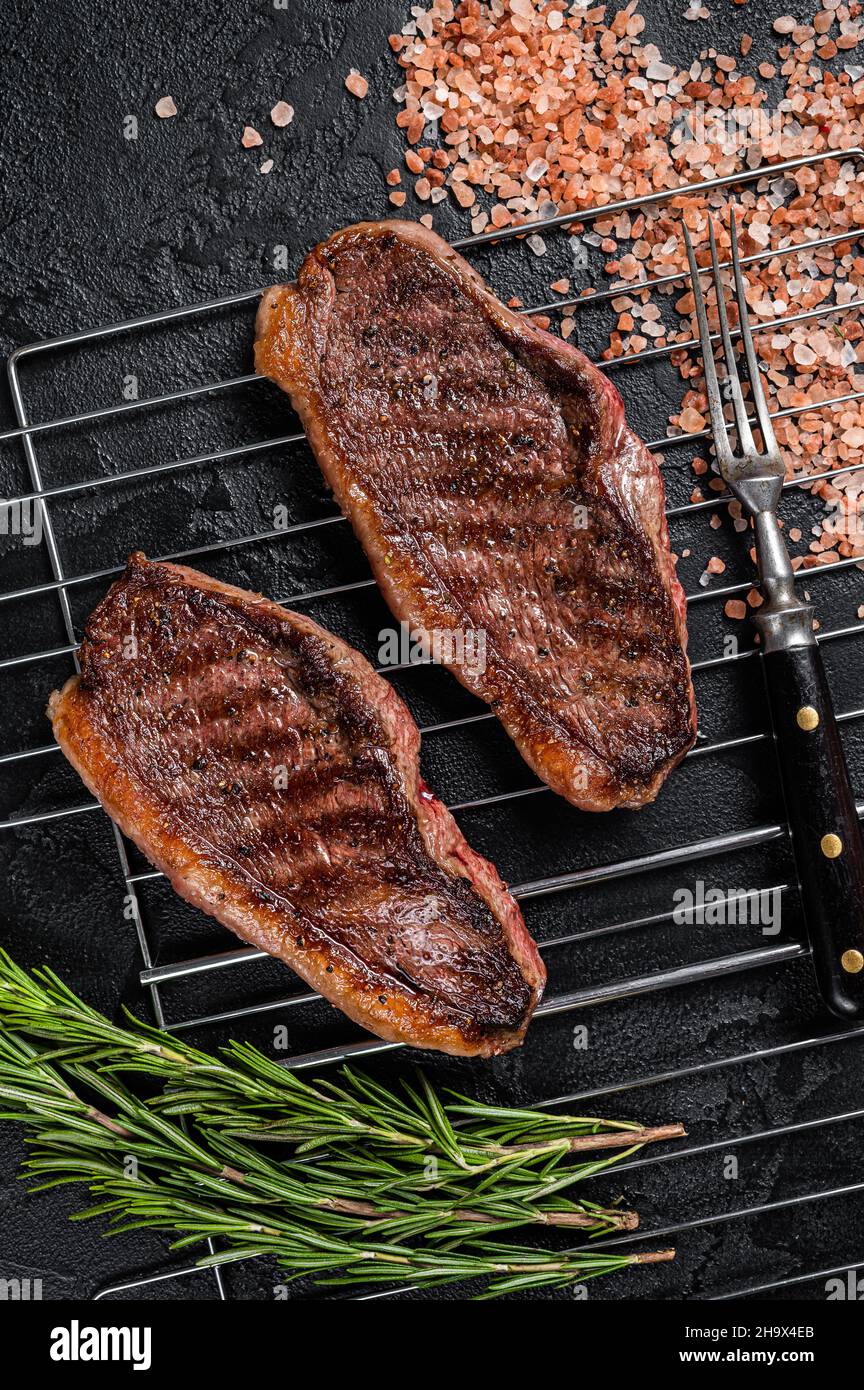 Rôti de chapeau grillé au barbecue ou bifteck de bœuf au sirloin du haut, viande frite sur le gril.Arrière-plan noir.Vue de dessus Banque D'Images
