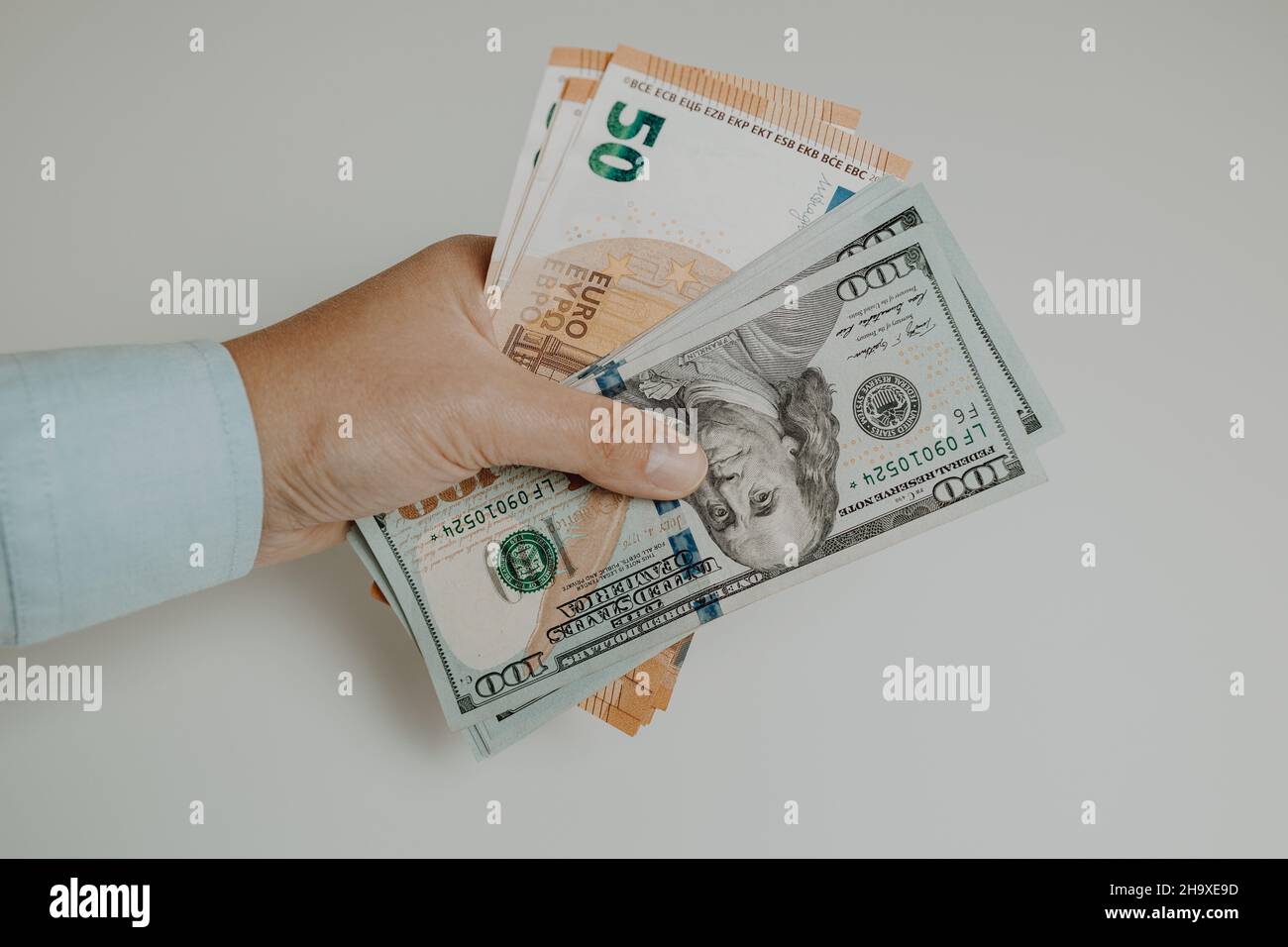 Un homme d'affaires tient à la main des billets d'euro en dollars américains.Investissement, succès et rentabilité. Banque D'Images