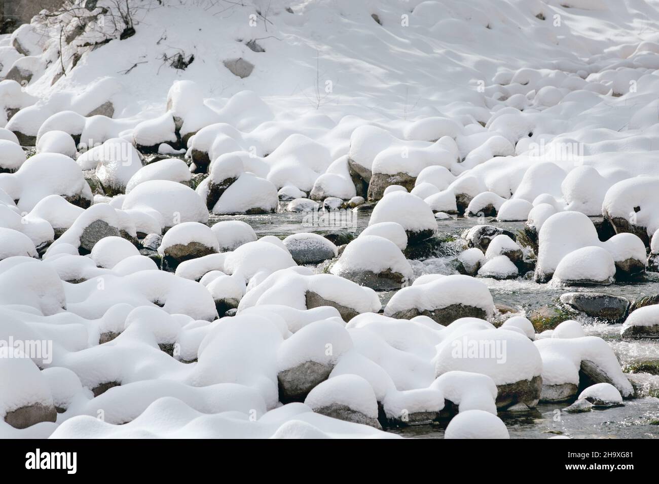 Paysage d'hiver avec pierres enneigées sur la rivière Banque D'Images