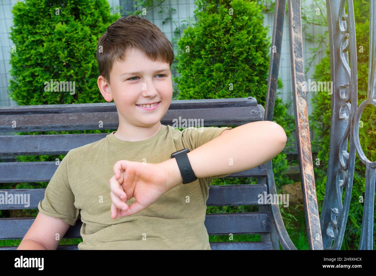 Un portrait extérieur d'un garçon heureux avec une montre intelligente, un gros plan en plein air Banque D'Images