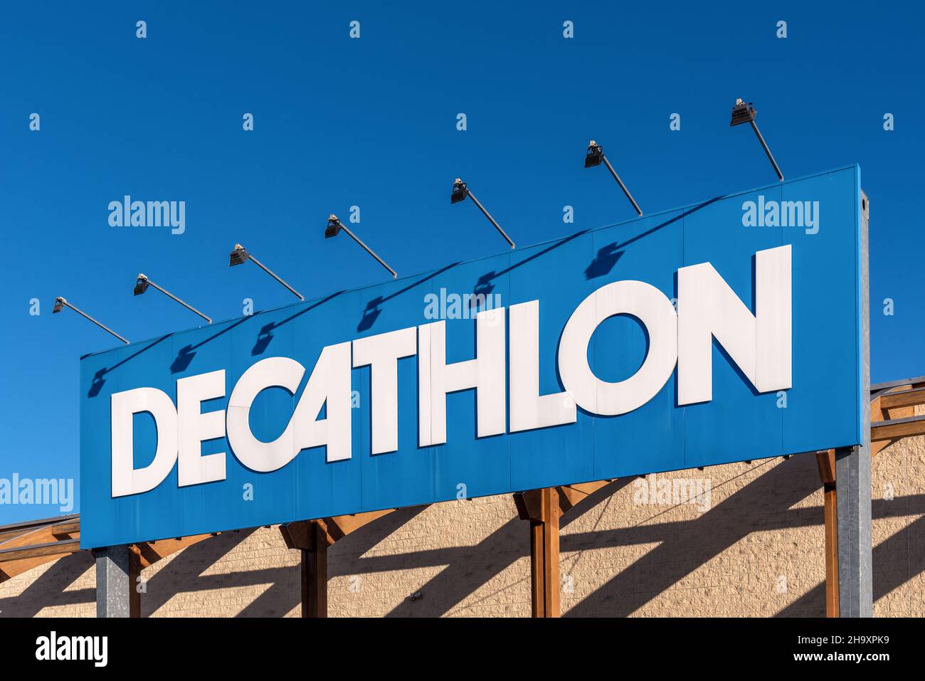 Turin, Italie - 6 décembre 2021 : logo DECATHLON sur le panneau à l'entrée du magasin sur ciel bleu, Decathlon est le plus grand détaillant d'articles de sport au monde Banque D'Images