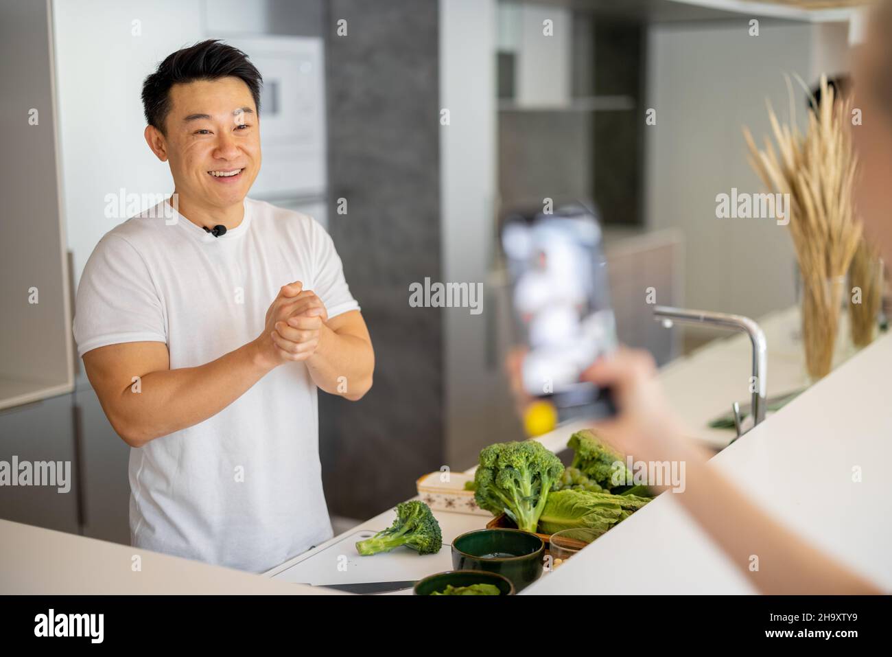 Femme prendre la vidéo sur smartphone de l'homme cuisinier salade Banque D'Images