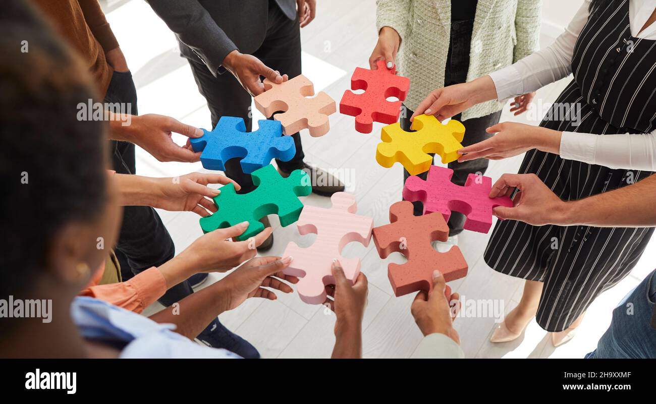 Arrière-plan de bannière avec une équipe de gens d'affaires reliant des pièces colorées de puzzle puzzle Banque D'Images
