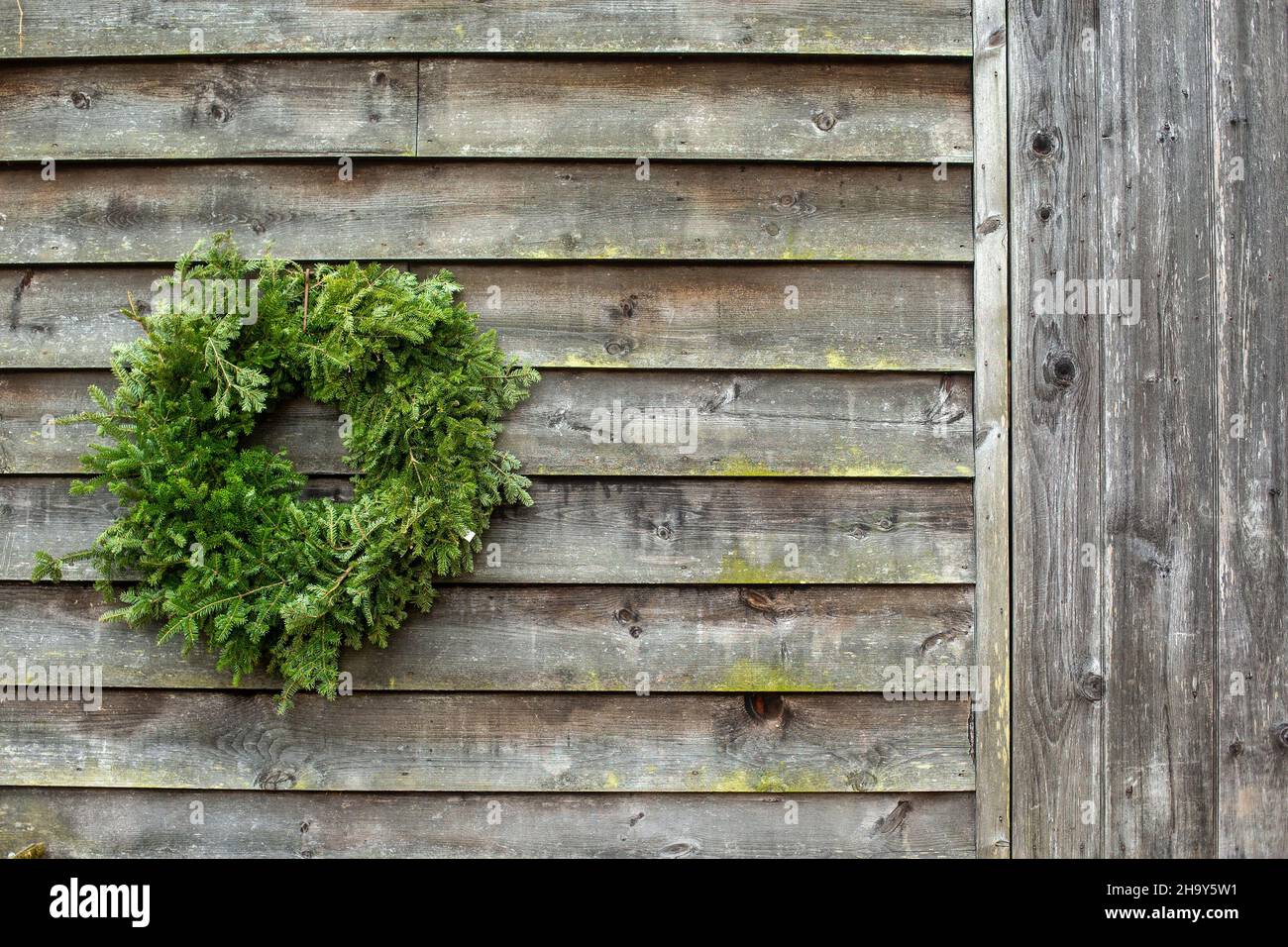 Une couronne de Noël sur un mur rustique de grange Banque D'Images