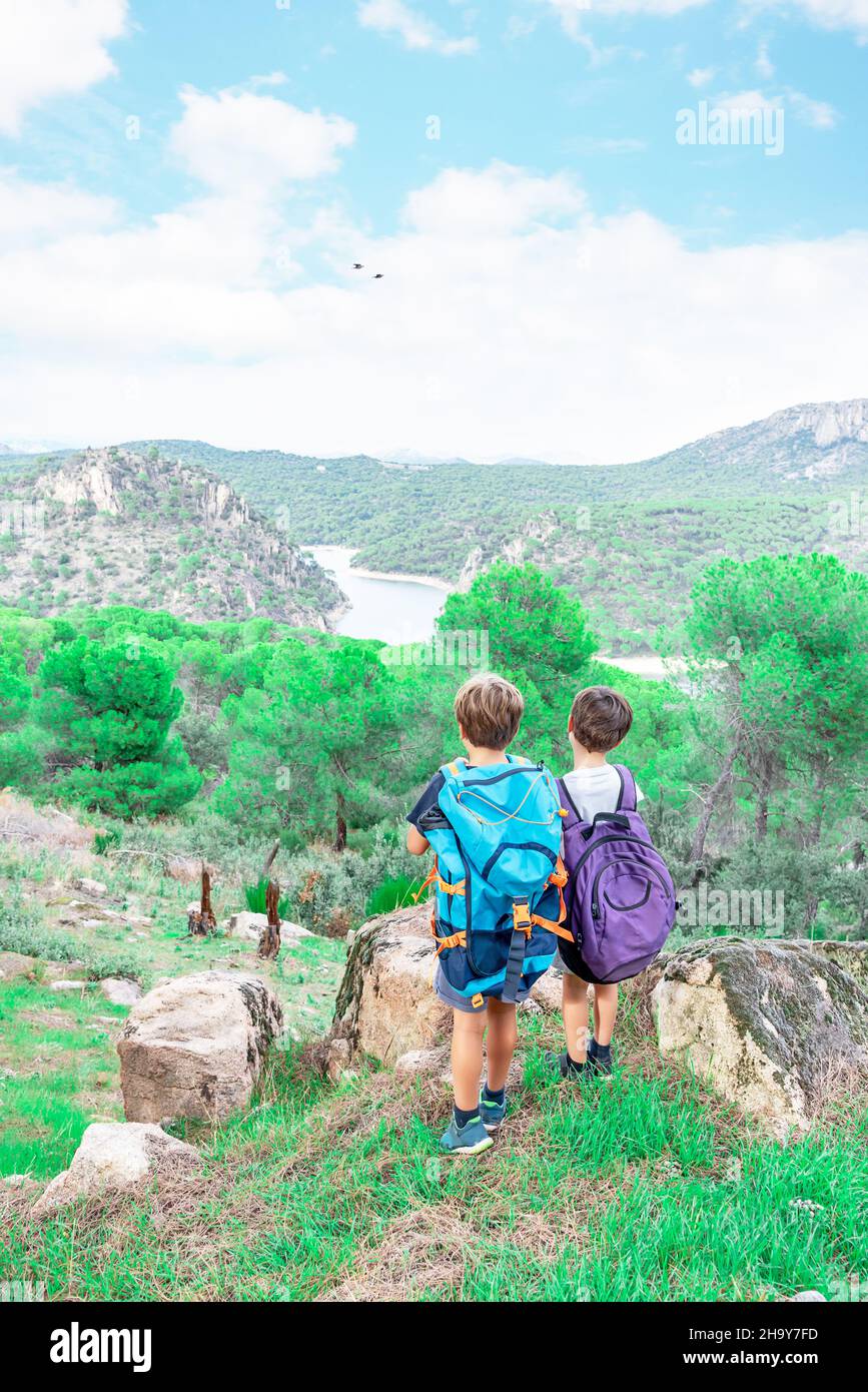 Deux enfants de randonnée avec leurs sacs à dos regardant l'horizon au milieu du Bush, contemplant le paysage.Des scouts de garçons qui ont fait de la randonnée dans la forêt Banque D'Images
