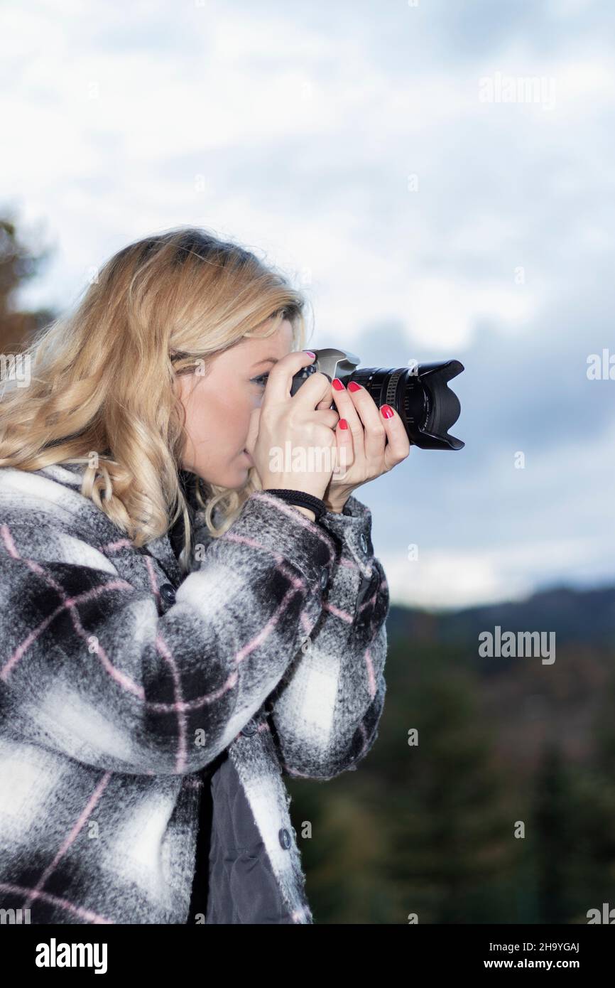 photographe blond en profil prenant une photo Banque D'Images