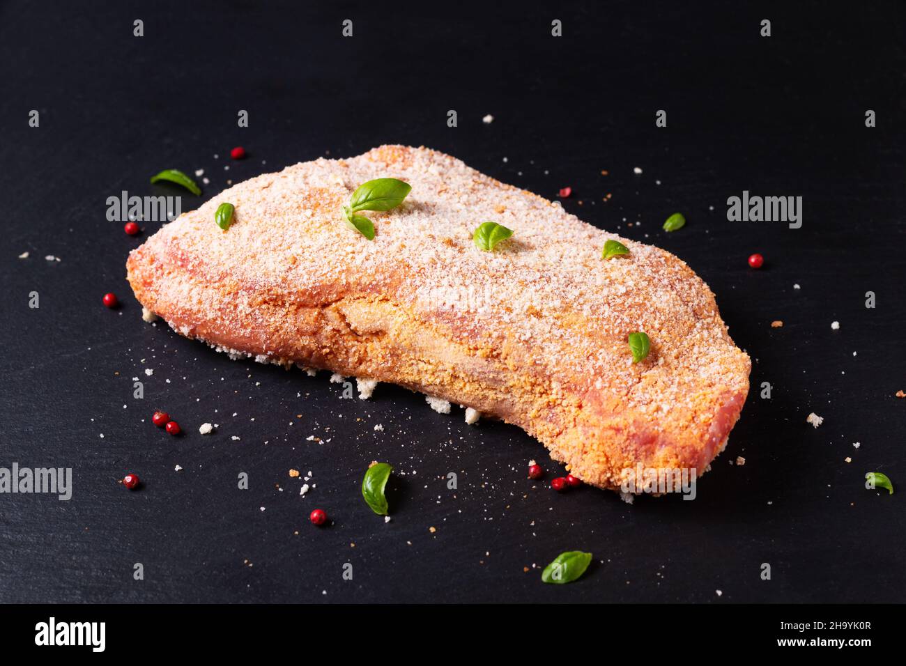 Concept alimentaire veau cordon bleu non cuit sur panneau en pierre d'ardoise noire avec espace de copie Banque D'Images