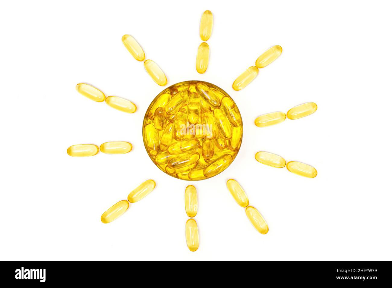 Capsules de gel souple oméga-3 d'huile de poisson translucide disposées en forme de soleil, isolées sur fond blanc.Supplément alimentaire stimulant l'immunité de la peau au soleil Banque D'Images