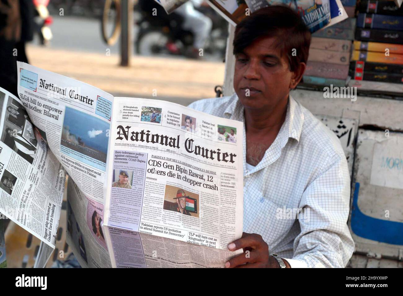 Un homme lisant le journal après que l'Inde ait perdu son premier chef d'état-major de la Défense (CEMD), le général Bipin Rawat, l'épouse Madhulika, 11 autres personnes dans un tragique accident mi-17V5 du broyeur de la FIA à Coonoor, dans le Tamil Nadu, à Karachi, le jeudi 09 décembre 2021. Banque D'Images