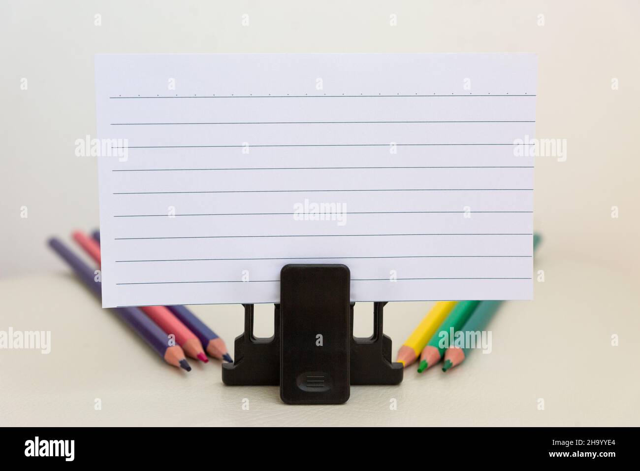 Accessoires d'école sur une table blanche, feuille de papier et crayons. Banque D'Images