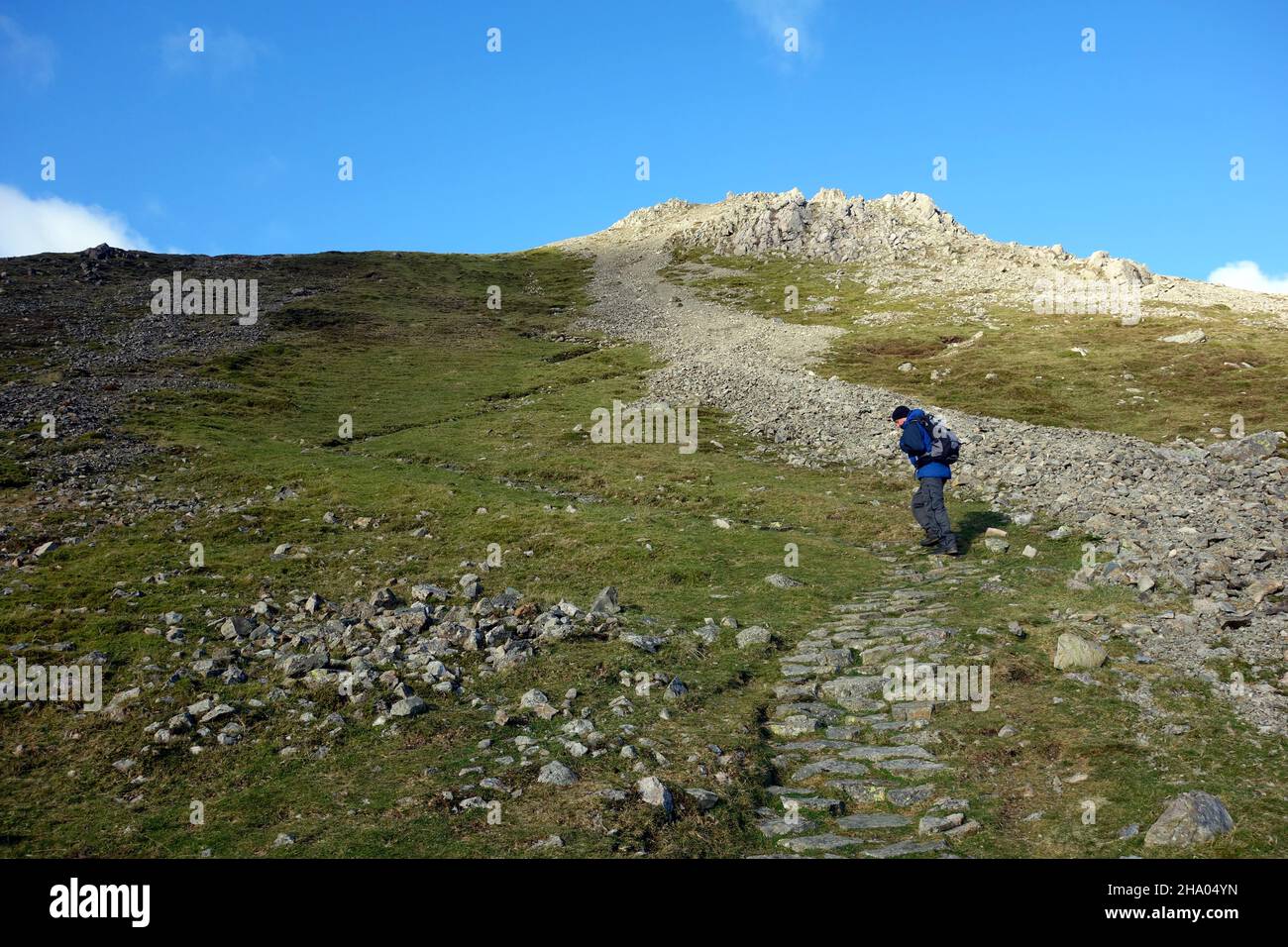 Single Lone Man grimpant sur le chemin du cri jusqu'au Wainwright 'High Crag' à Buttermere, Lake District National Park, Cumbria, Angleterre, Royaume-Uni. Banque D'Images