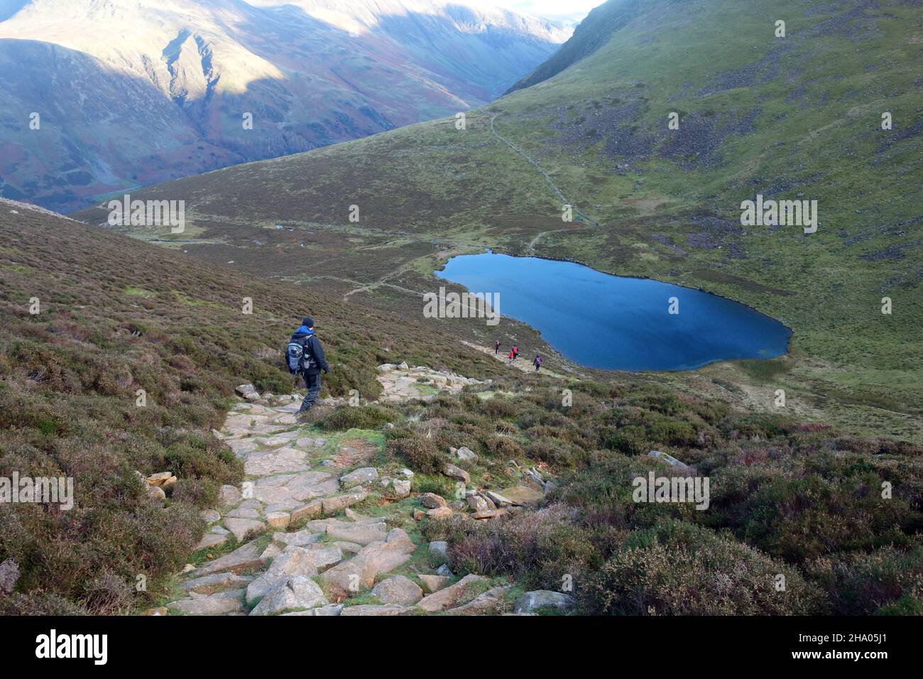 Single Lone Man marchant sur le chemin de Bleaberry Tarn depuis le Wainwright 'Red Pike' à Buttermere, Lake District National Park, Cumbria, Angleterre, Royaume-Uni. Banque D'Images