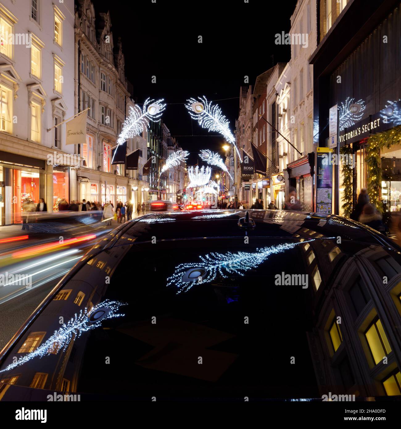 Londres, Grand Londres, Angleterre, décembre 04 2021 : les lumières de Noël se reflètent dans un pare-brise de voitures la nuit sur New Bond Street. Banque D'Images