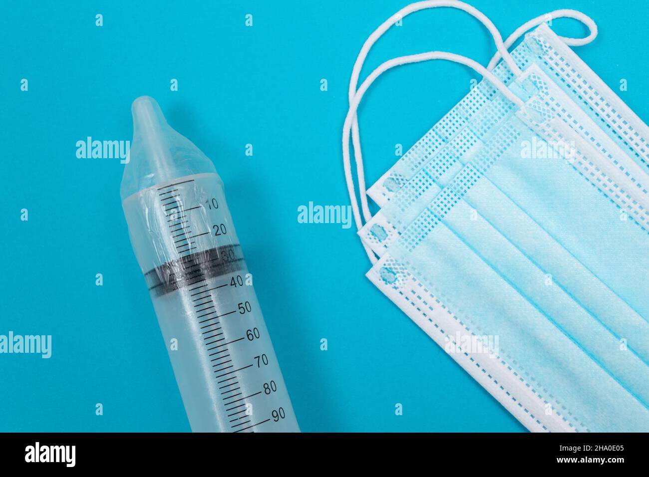 Vaccin sûr, anti-vaccin concept - seringue dans un condom se trouve sur la table bleue en clinique ou à l'hôpital. Méfiance à l'égard de la vaccination. Immunité naturelle. Scepticisme à propos du vaccin. Liberté et droits de l'homme Banque D'Images