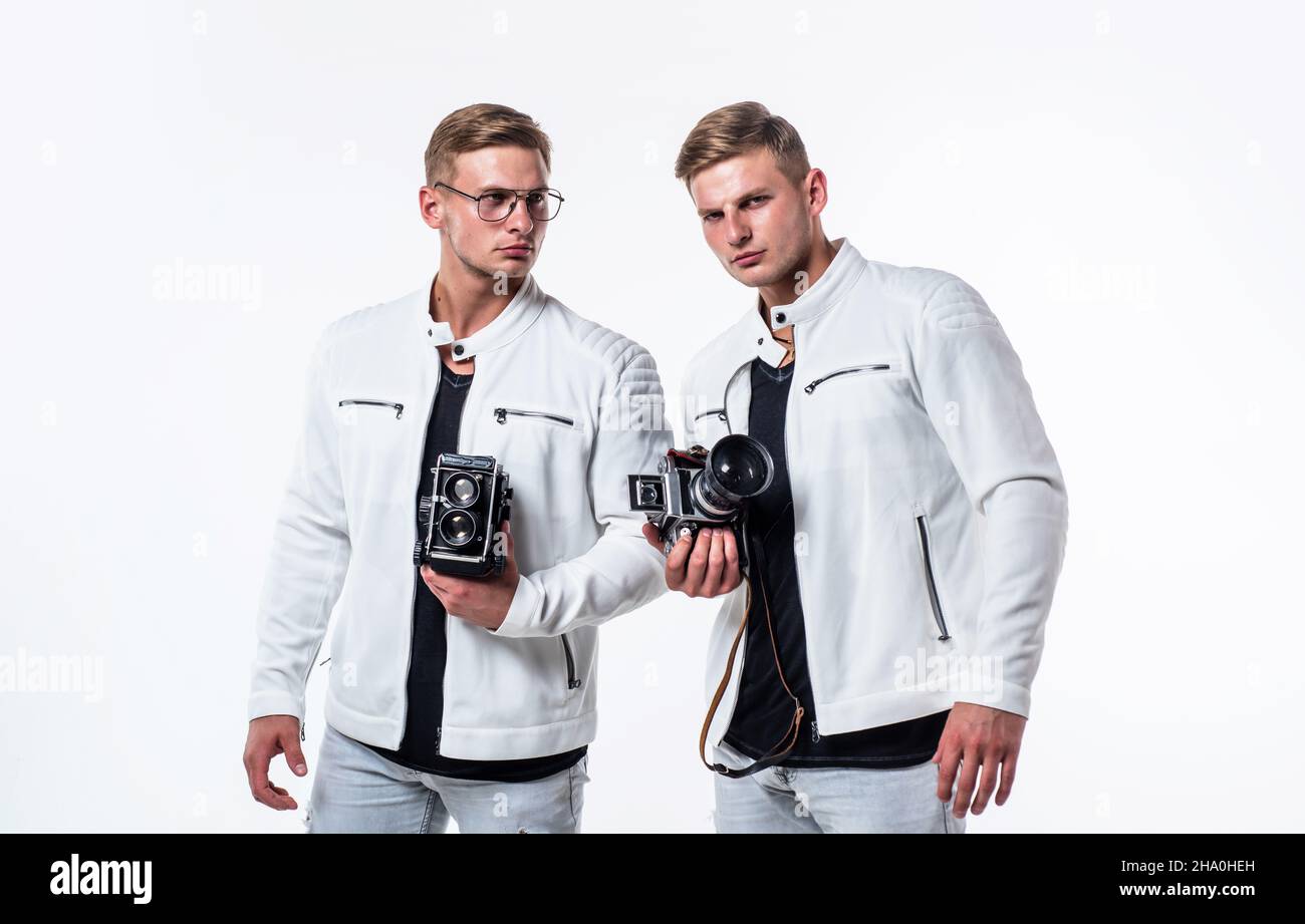 les deux frères hommes se ressemblent utilisent un appareil photo vintage pour photographier Banque D'Images
