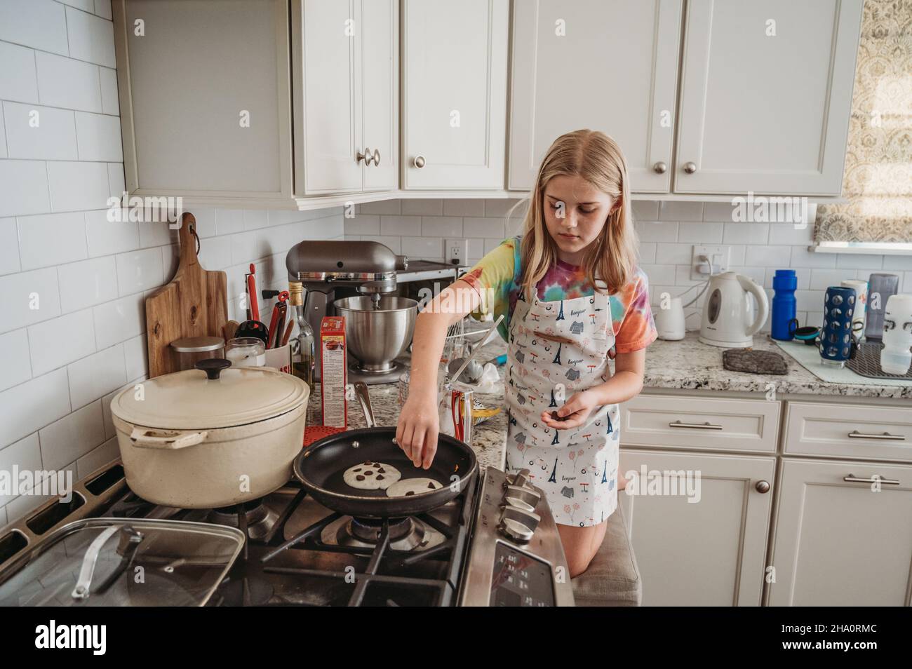 Une jeune fille fait des crêpes aux pépites de chocolat Banque D'Images