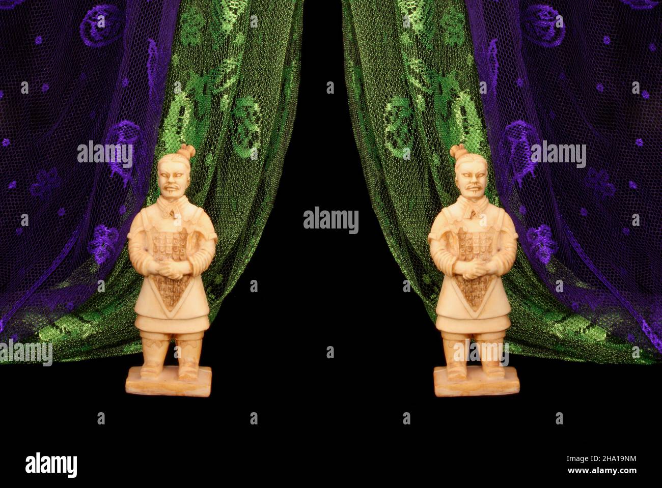 Statues de guerrier asiatique sur fond noir avec foulard vert et violet Banque D'Images
