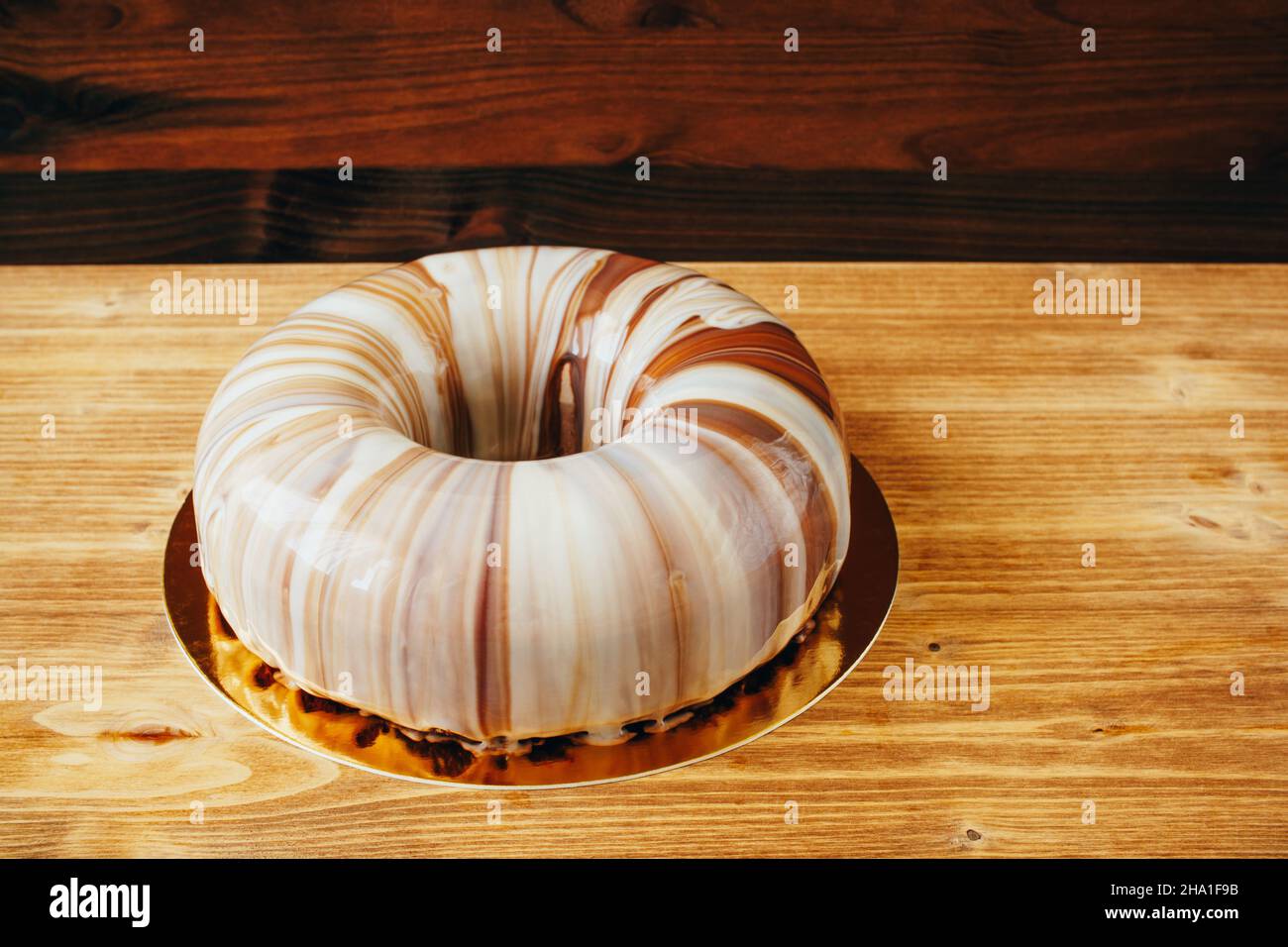 Mousse le gâteau avec glaçage miroir sur une assiette dorée sur la table  Photo Stock - Alamy