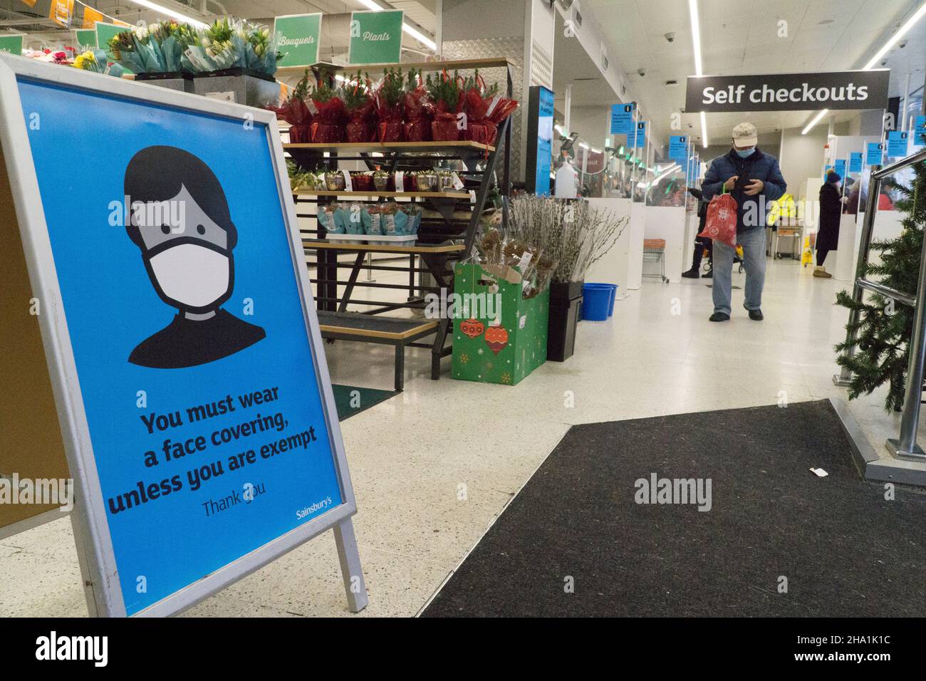 Londres, Royaume-Uni, 6 décembre 2021: Les masques sont désormais obligatoires dans les magasins, sauf si les clients sont médicalement exemptés, dans l'espoir qu'ils pourraient freiner la propagation de la variante Omicron du coronavirus, qui est censé être déjà en transmission communautaire.À cette succursale de Sainsbury's, un panneau de signalisation à l'entrée demande aux clients de coopérer pour assurer la sécurité des autres.Anna Watson/Alay Live News Banque D'Images
