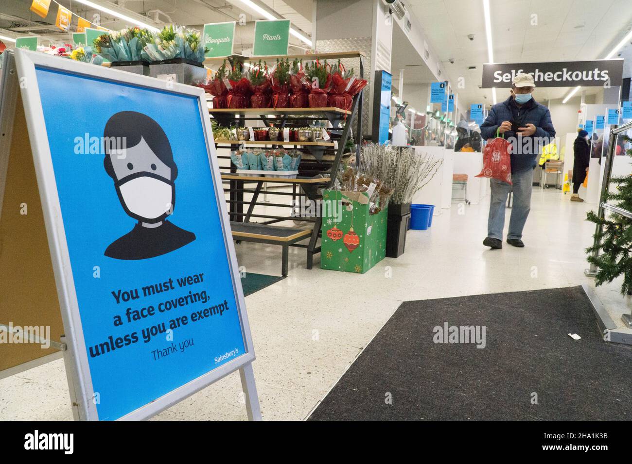 Londres, Royaume-Uni, 6 décembre 2021: Les masques sont désormais obligatoires dans les magasins, sauf si les clients sont médicalement exemptés, dans l'espoir qu'ils pourraient freiner la propagation de la variante Omicron du coronavirus, qui est censé être déjà en transmission communautaire.À cette succursale de Sainsbury's, un panneau de signalisation à l'entrée demande aux clients de coopérer pour assurer la sécurité des autres.Anna Watson/Alay Live News Banque D'Images
