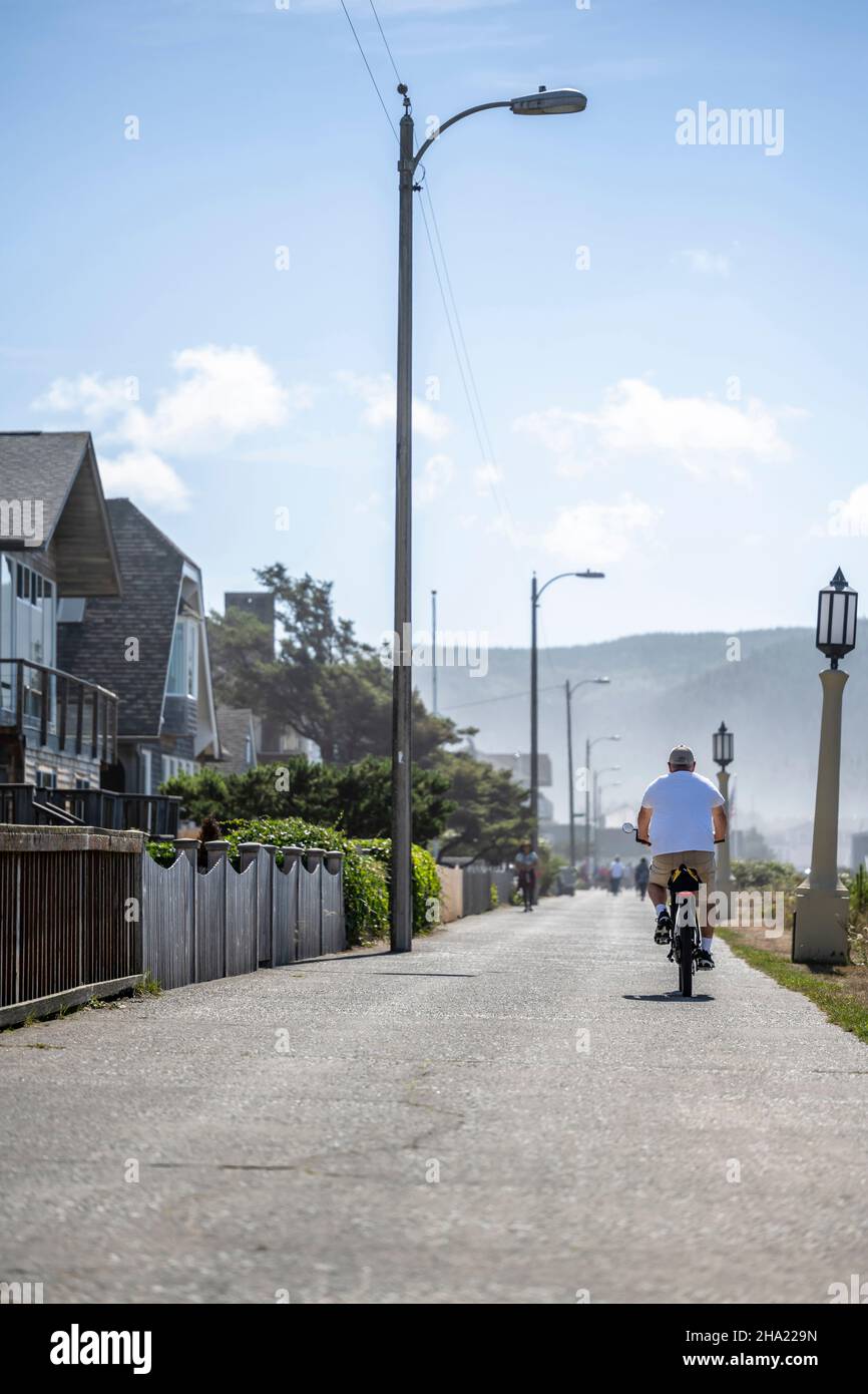 Les hommes amateurs âgés en vêtements d'été voyagent sur les vélos de montagne sur le sentier le long de la brume de l'océan Pacifique Nord-Ouest préférant une hea active Banque D'Images