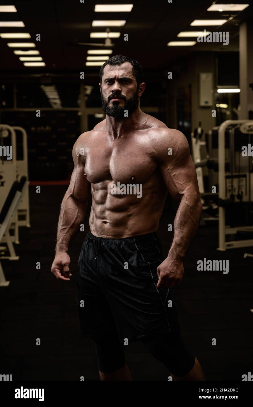 jeune homme fort avec barbe et muscles abdominaux de forme physique parfaits dans la salle de sport Banque D'Images