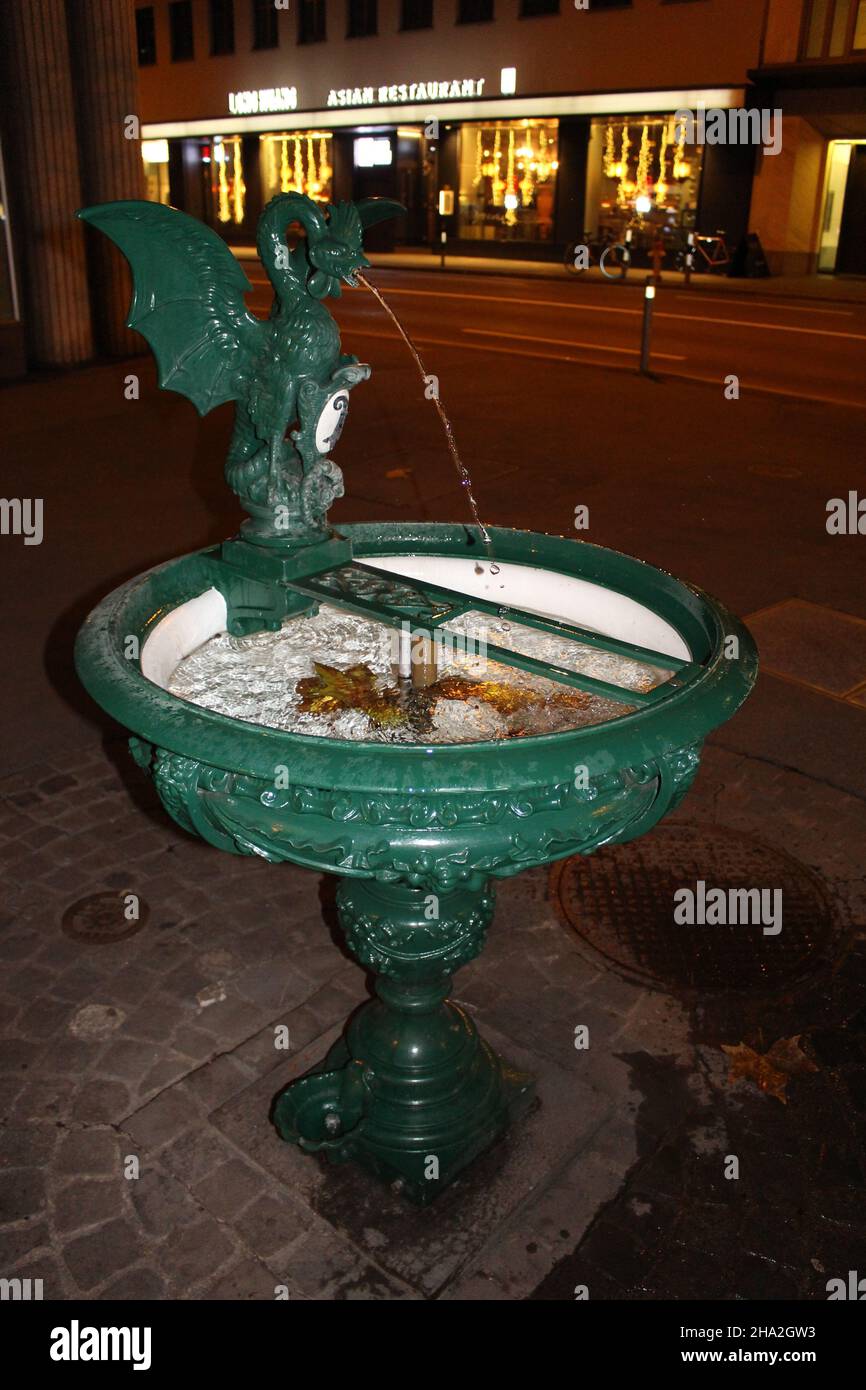 Fontaine verte avec eau et feuilles automnales à l'intérieur.Une des 1200 fontaines à boire gratuites de Zurich Banque D'Images