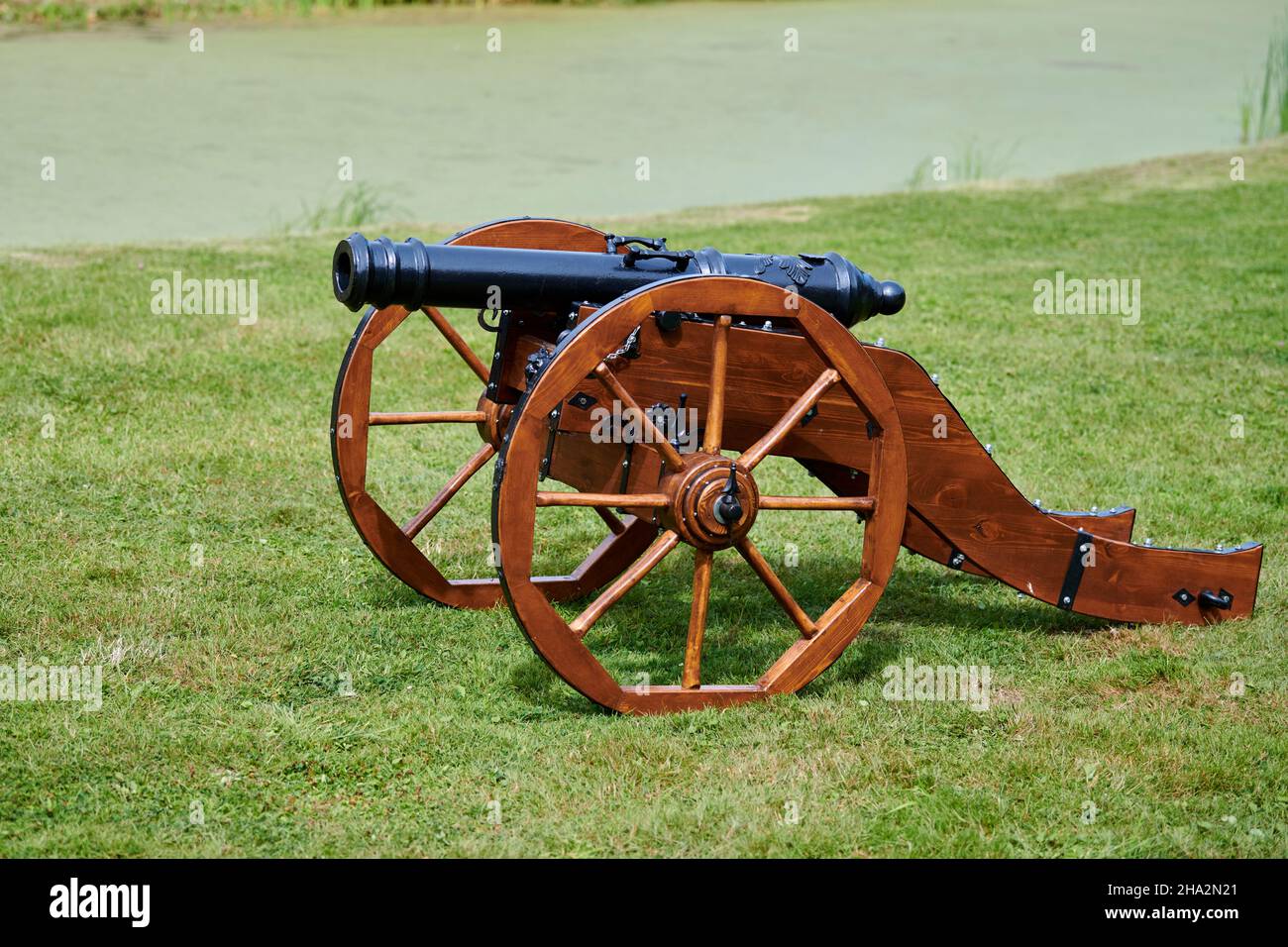 Modèle de canon restauré pour la défense du château, fond vert de pelouse.Artillerie arme de grand calibre, ancien canon sur roues en bois.Protéger contre les batteries Banque D'Images