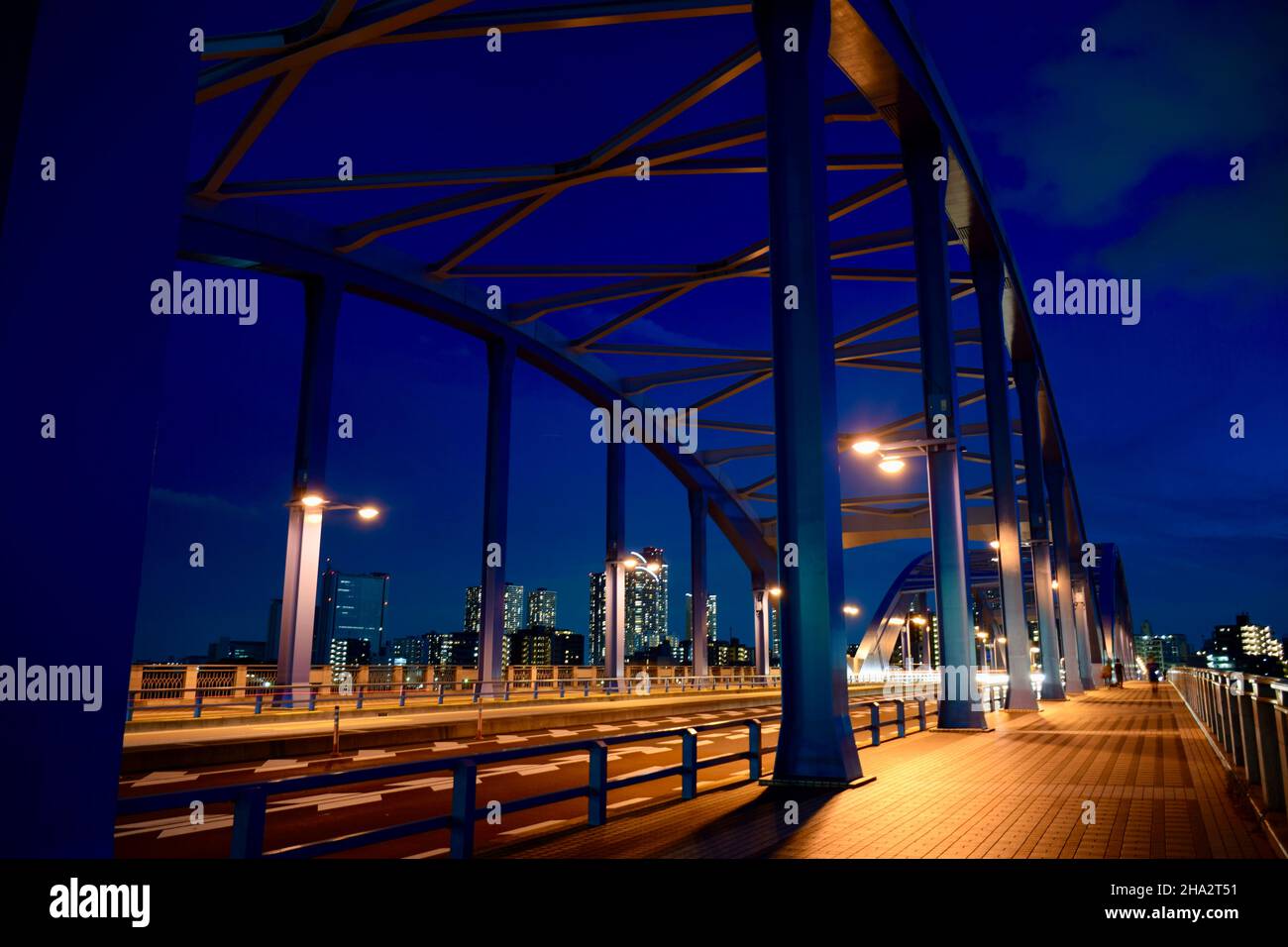 Vue de nuit sur un pont au-dessus d'une rivière en face des gratte-ciels Banque D'Images