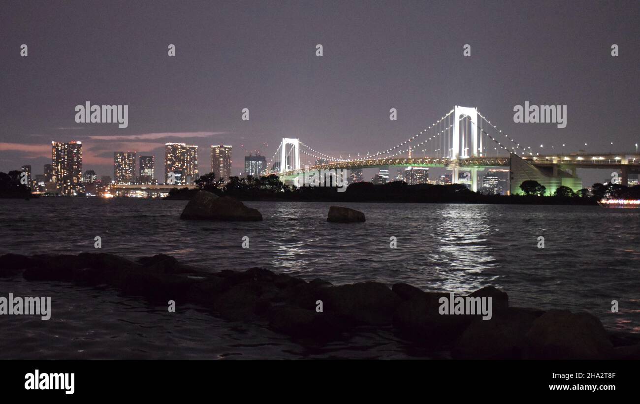 Pont Rainbow la nuit en face des gratte-ciel de Tokyo Banque D'Images