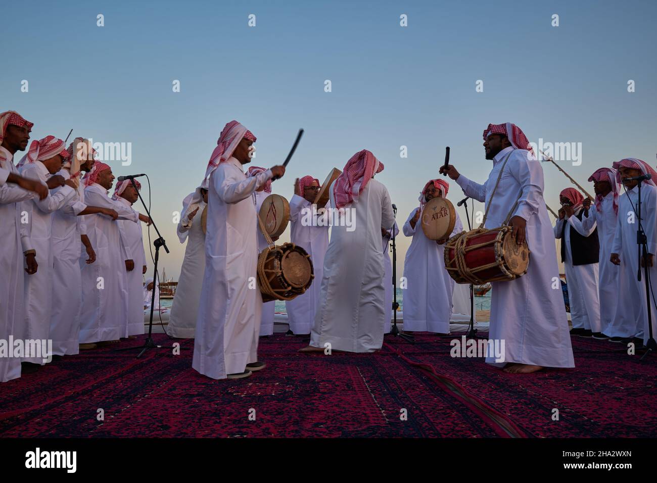 Danse traditionnelle du folklore du Qatar (danse de l'Ardah) à Katara onzième festival traditionnel de dhow à Doha Qatar vue au coucher du soleil Banque D'Images