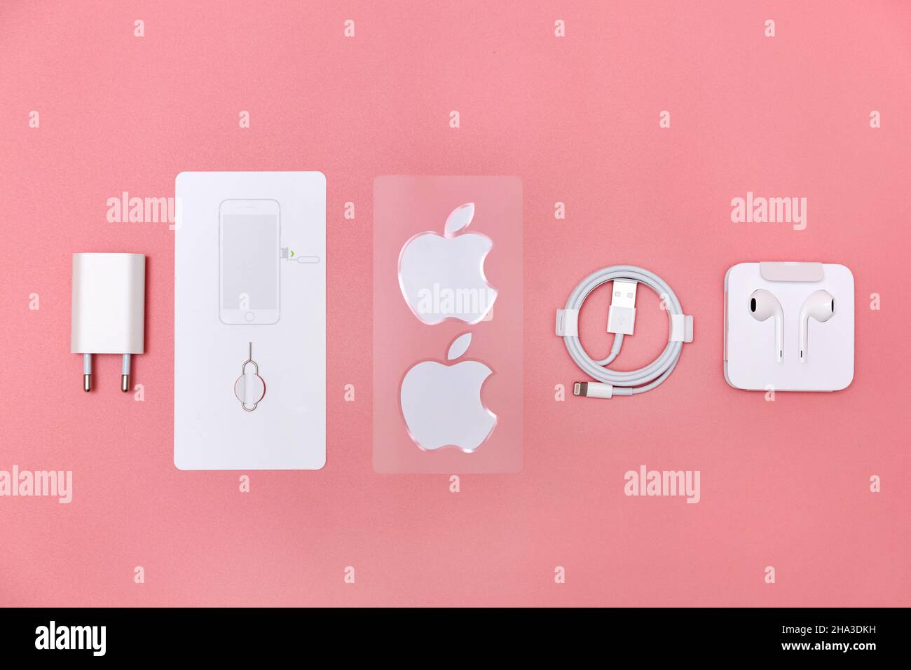 3 avril 2021, Kiev, Ukraine, iPhone se.Pose plate d'accessoires pour smartphone modernes, chargeur et écouteurs sur fond rose Banque D'Images