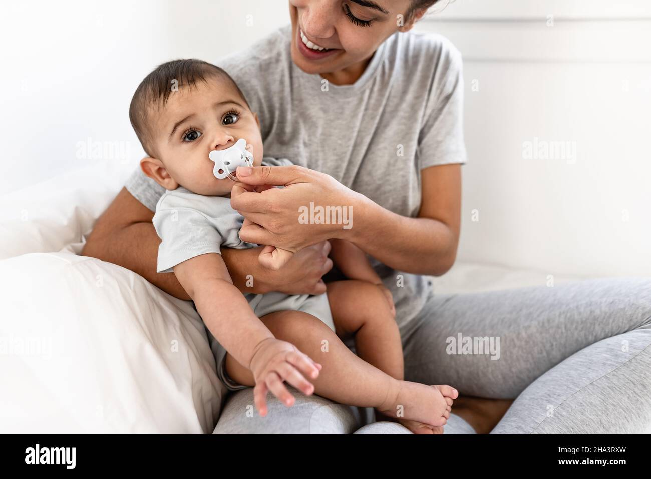 Bonne mère s'amuser avec son petit bébé au lit - concept de famille et de maternité Banque D'Images