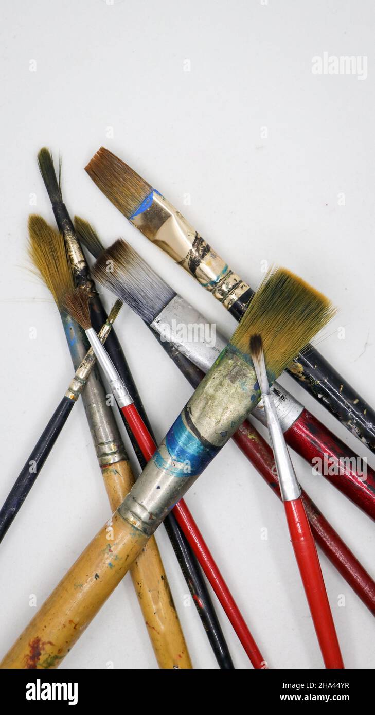 plan vertical d'un groupe d'artistes en bois et en plastique peignant des pinceaux avec des taches de couleur les unes sur les autres isolées sur un fond blanc Banque D'Images